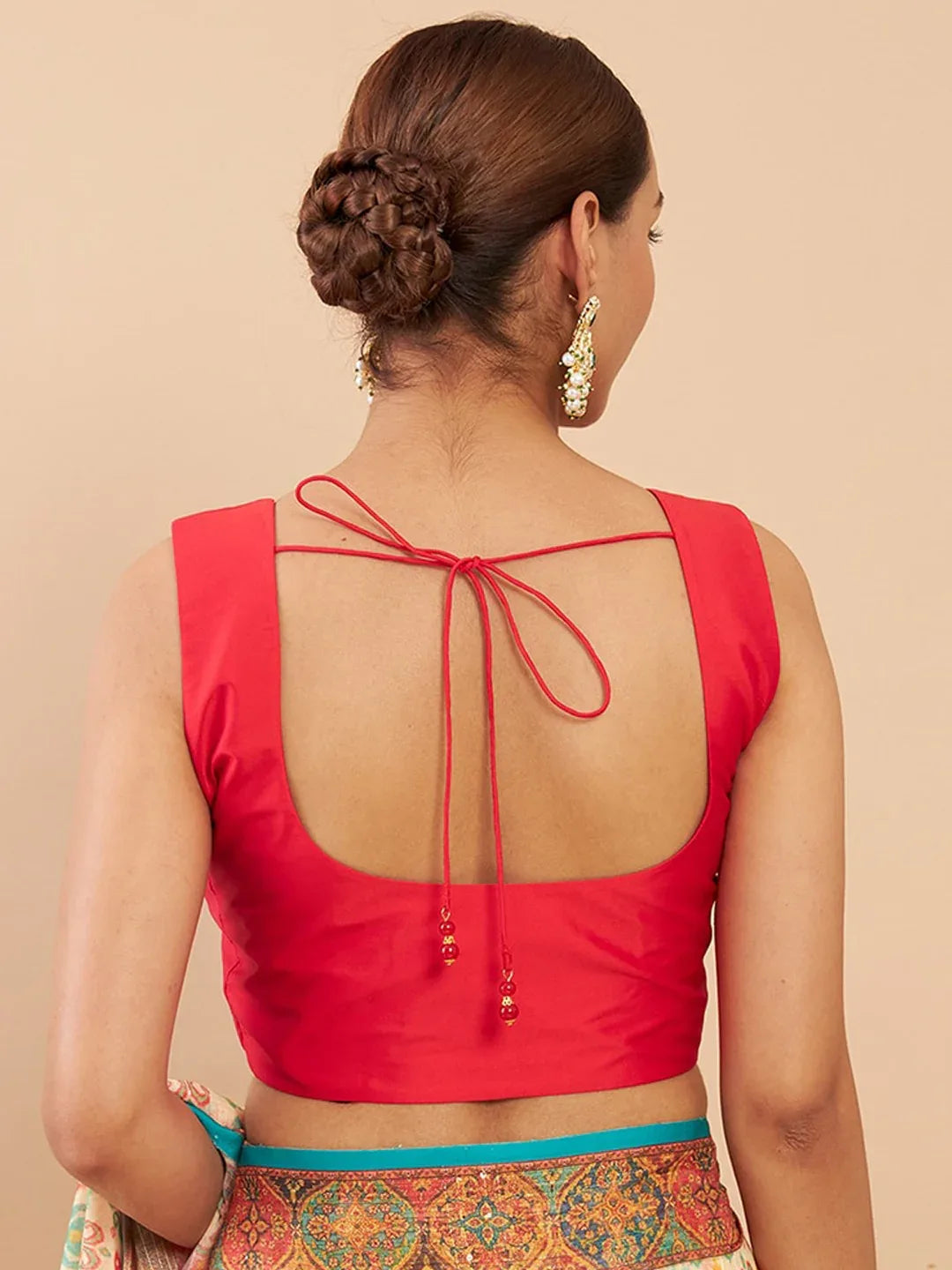 Red blouse with open back worn by a person on a beige background Glanzavi