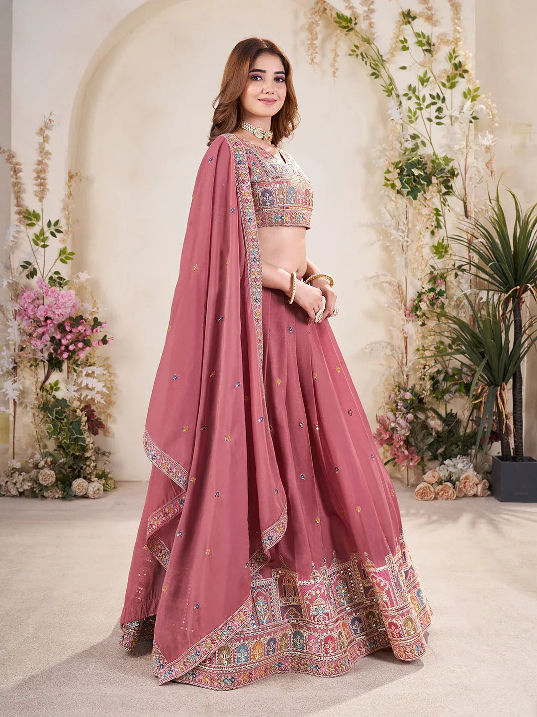 Woman wearing a light blue embroidered Lehenga with a matching blouse in a decorated indoor setting Glanzavi
