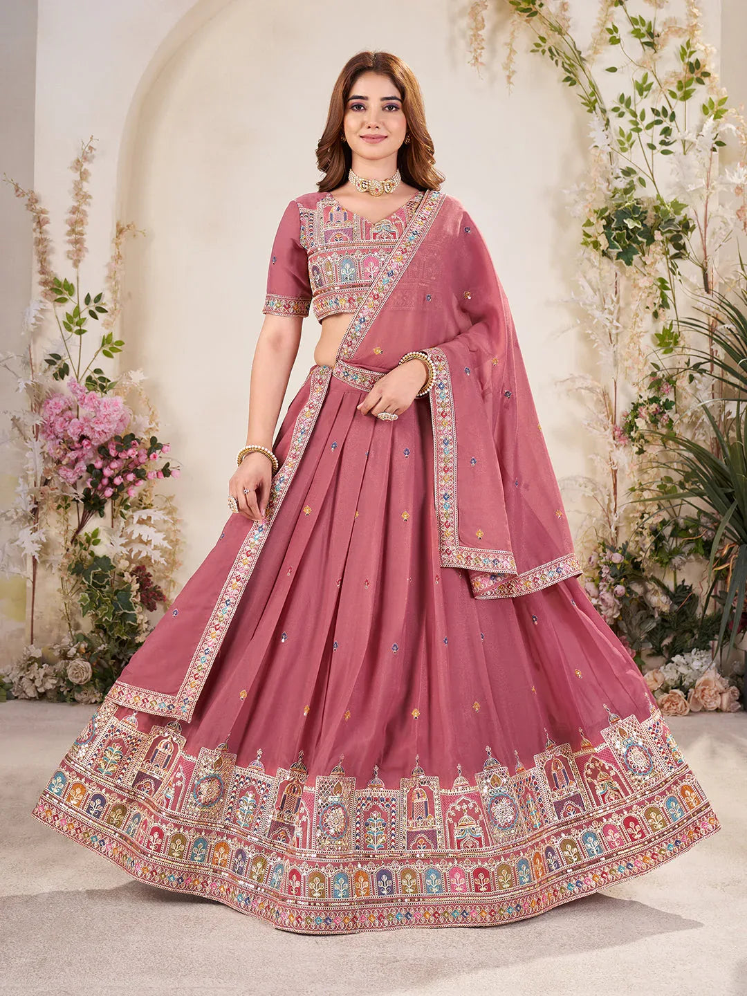 Woman wearing a rose Pink embroidered traditional outfit with a floral background Glanzavi