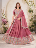 Woman wearing a rose Pink embroidered traditional outfit with a floral background Glanzavi
