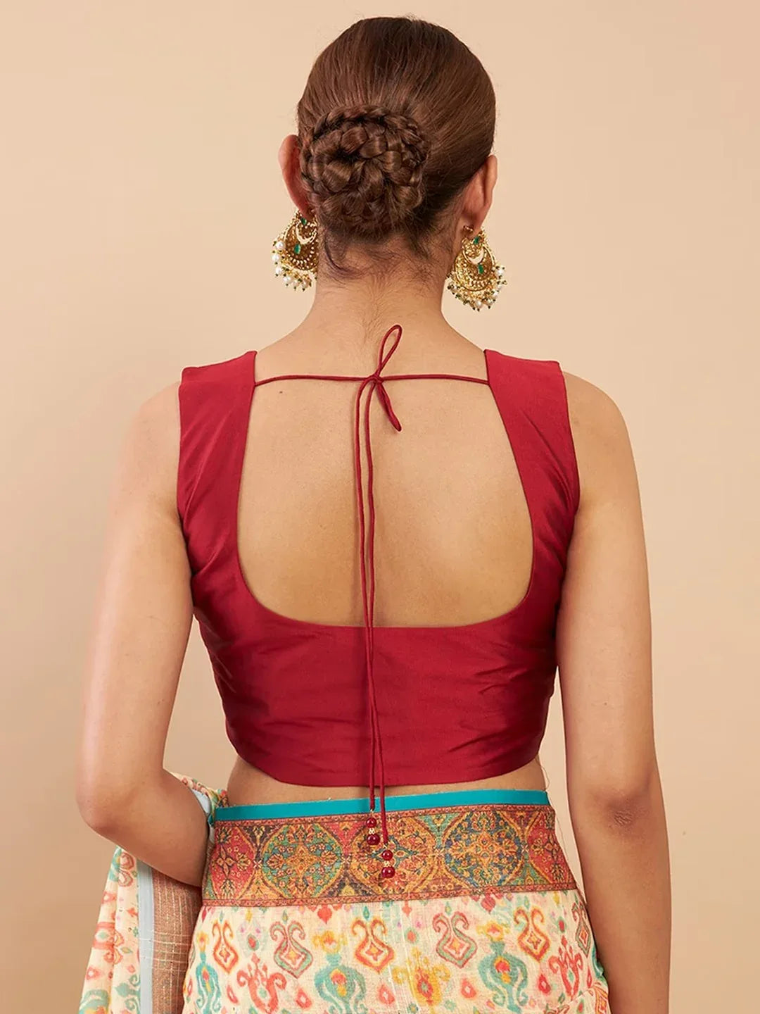 Red blouse with open back worn by a person on a beige background Glanzavi