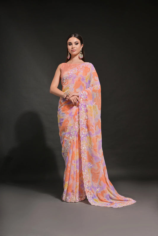 A woman modeling a Peach-Orange Pastel Tie-Dye Saree with Sequin & Floral Embroidery Border Glanzavi