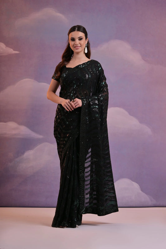 Woman in a black saree with a cloud-patterned backdrop Glanzavi