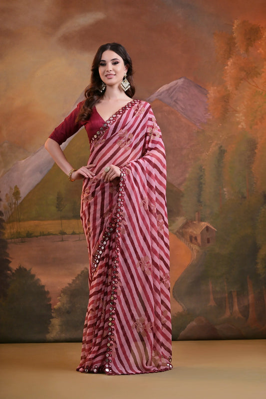 A woman modeling a maroon and pink striped saree with mirror and sequin embellishments, paired with a deep maroon blouse Glanzavi