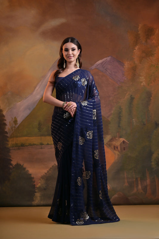 Woman in a blue saree with floral patterns against a scenic backdrop Glanzavi