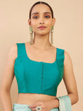 Woman wearing a teal blouse with a beige background Glanzavi