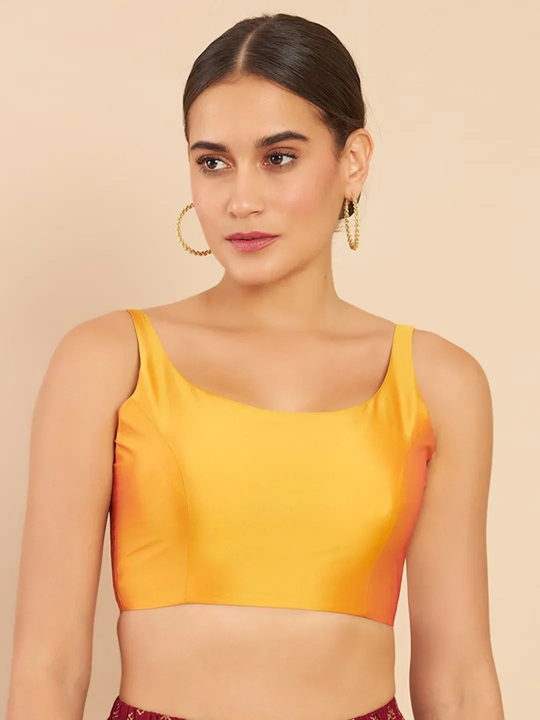 Woman wearing a yellow top against a beige background Glanzavi