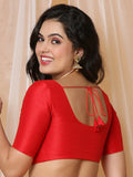 Woman wearing a red blouse with a beige curtain background Glanzavi