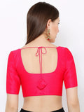 Woman wearing a bright pink blouse with a unique back design on a white background Glanzavi