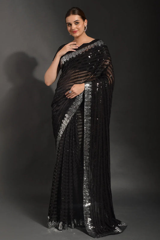 Woman wearing a black saree with silver sequin details against a gray background Glanzavi