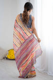 Woman holding a colorful striped saree in a minimal indoor setting Glanzavi