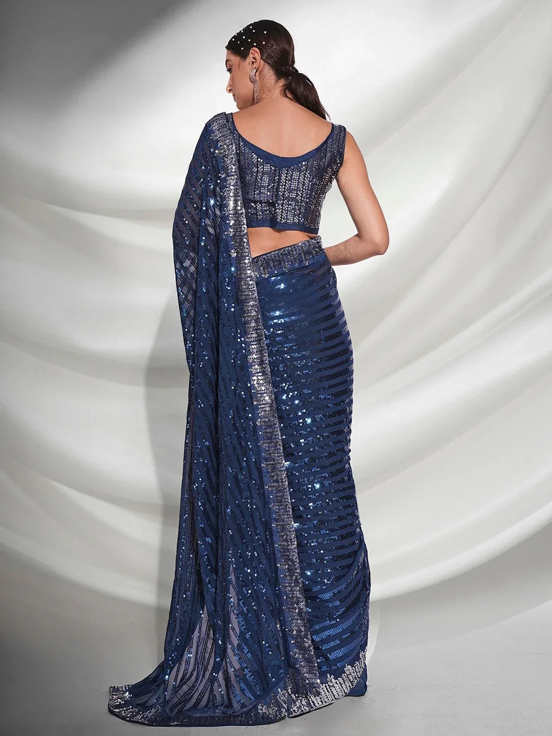 Woman wearing a blue saree with a white background Glanzavi