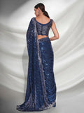 Woman wearing a blue saree with a white background Glanzavi