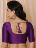 Woman wearing a purple blouse with a unique back design against a beige background Glanzavi