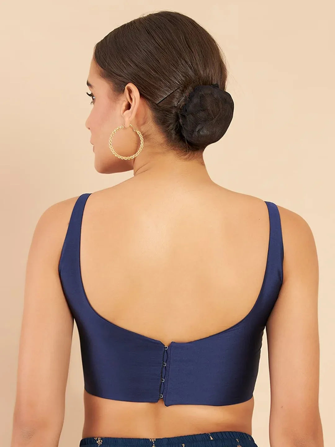 Woman wearing a blue top with a beige background Glanzavi