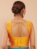 Woman wearing a yellow blouse with a sheer back design on a beige background Glanzavi