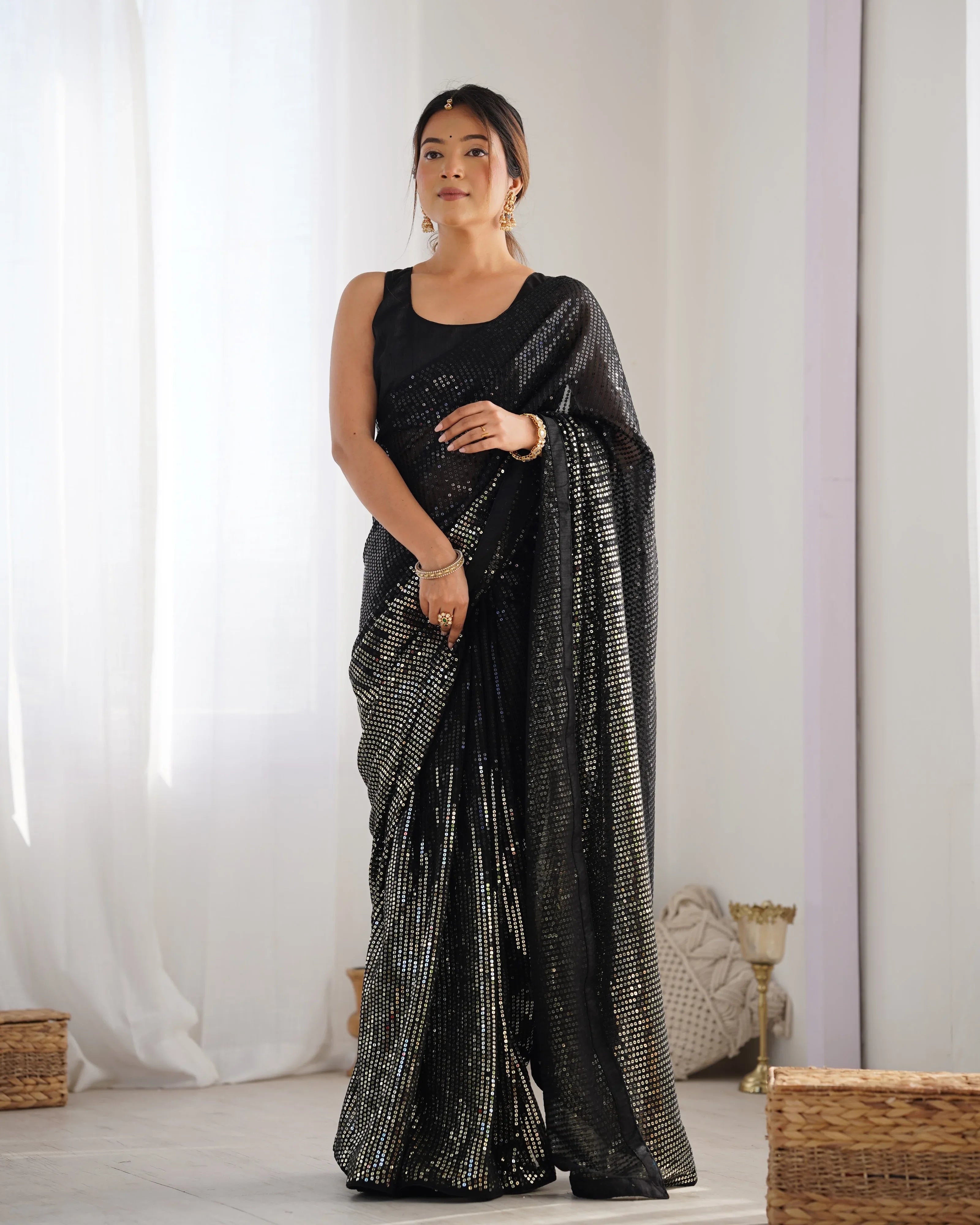 Woman wearing a black saree with silver patterns in a minimalistic setting Glanzavi
