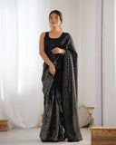 Woman wearing a black saree with silver patterns in a minimalistic setting Glanzavi
