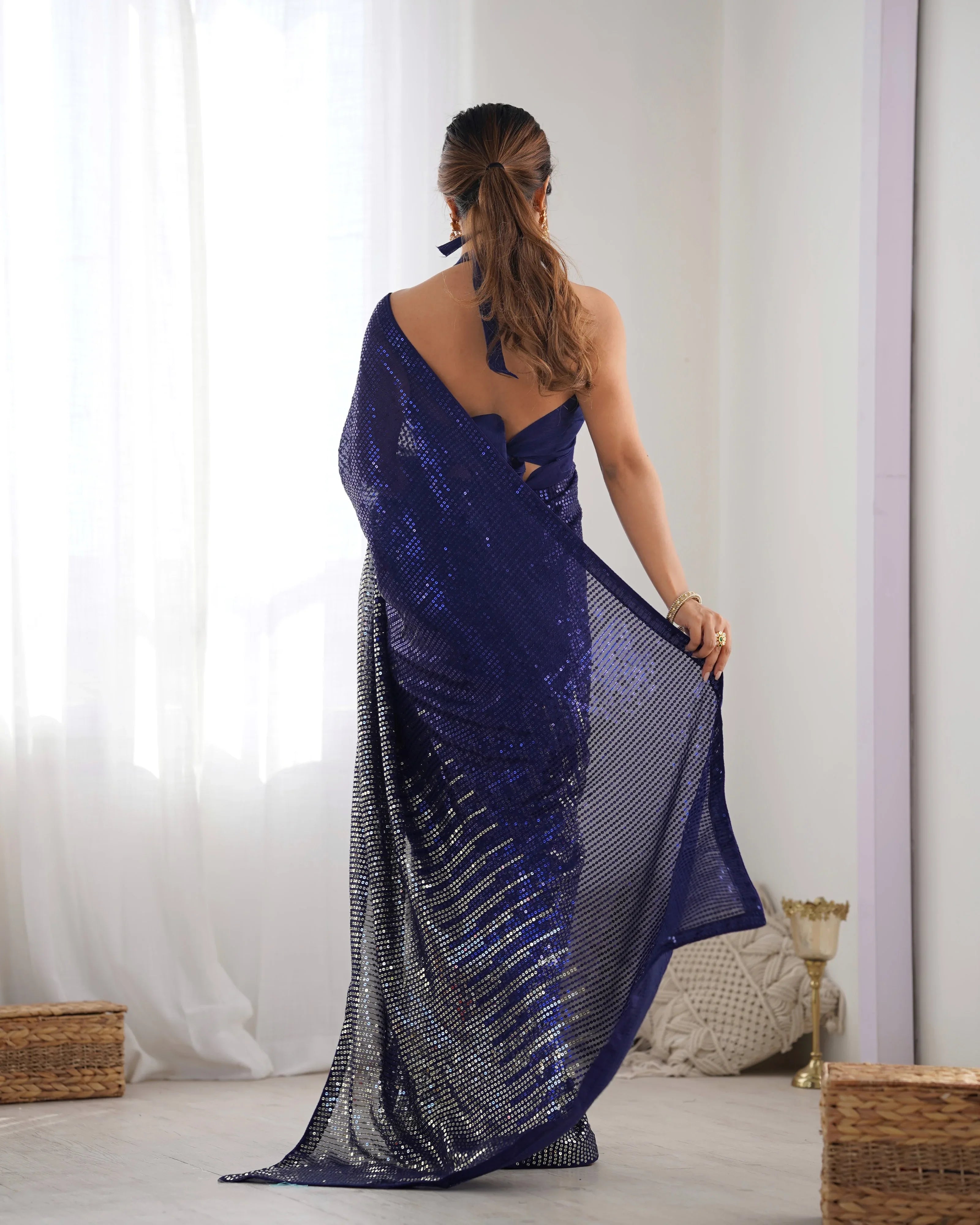 Woman wearing a blue saree with a white background Glanzavi