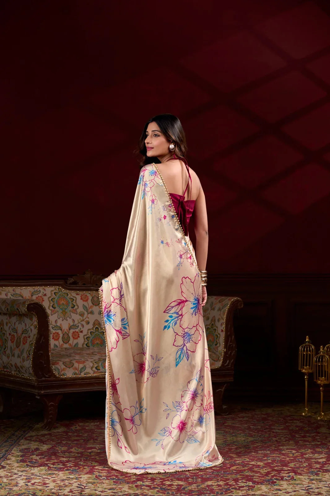 Woman wearing a floral saree in an elegant room setting Glanzavi