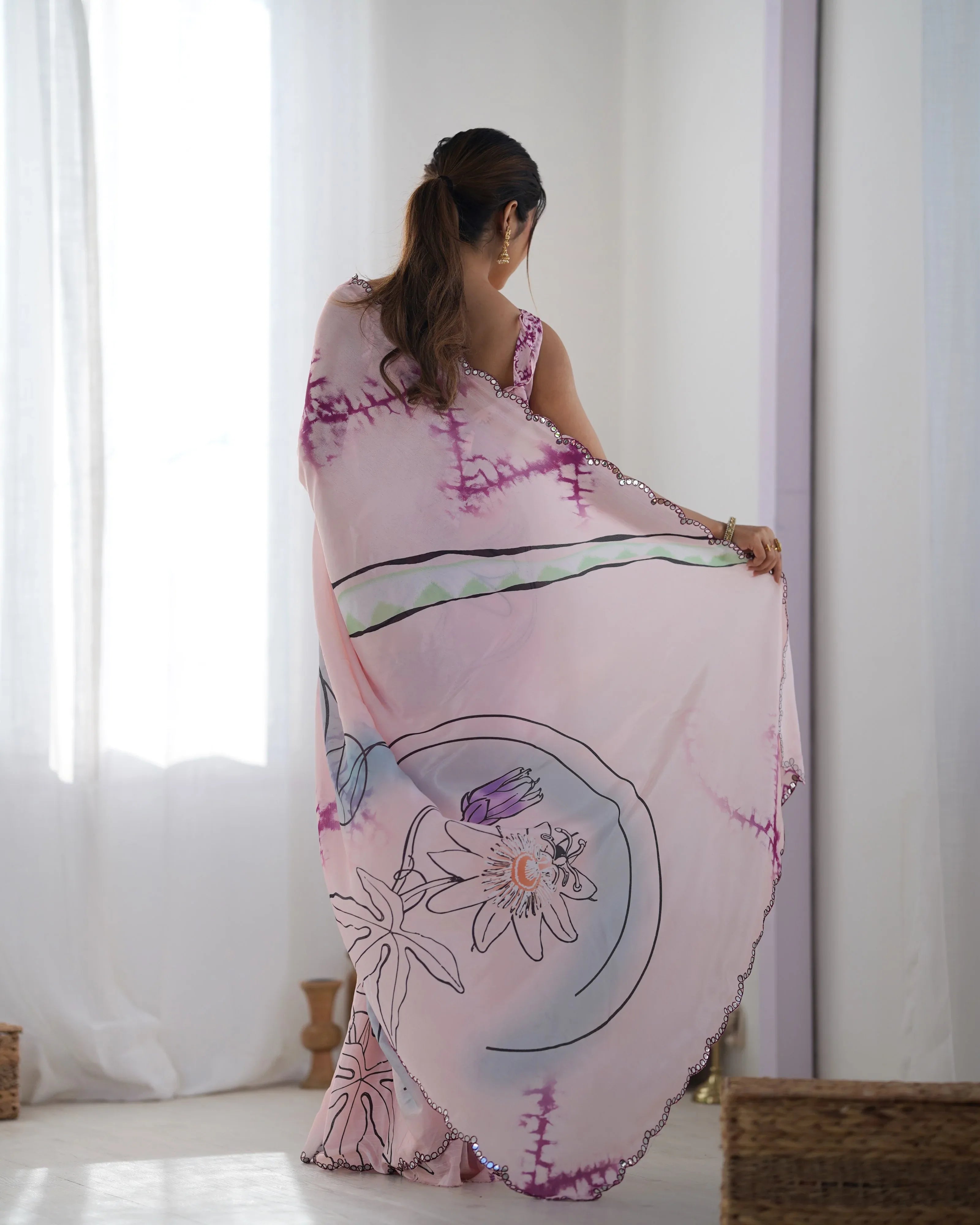 Woman wearing a pink floral dress with a white curtain background Glanzavi