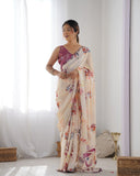 Woman wearing a floral saree standing in a bright room with white curtains Glanzavi