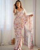 A woman modeling a soft pastel pink floral georgette saree with printed ethnic border and blouse piece Glanzavi