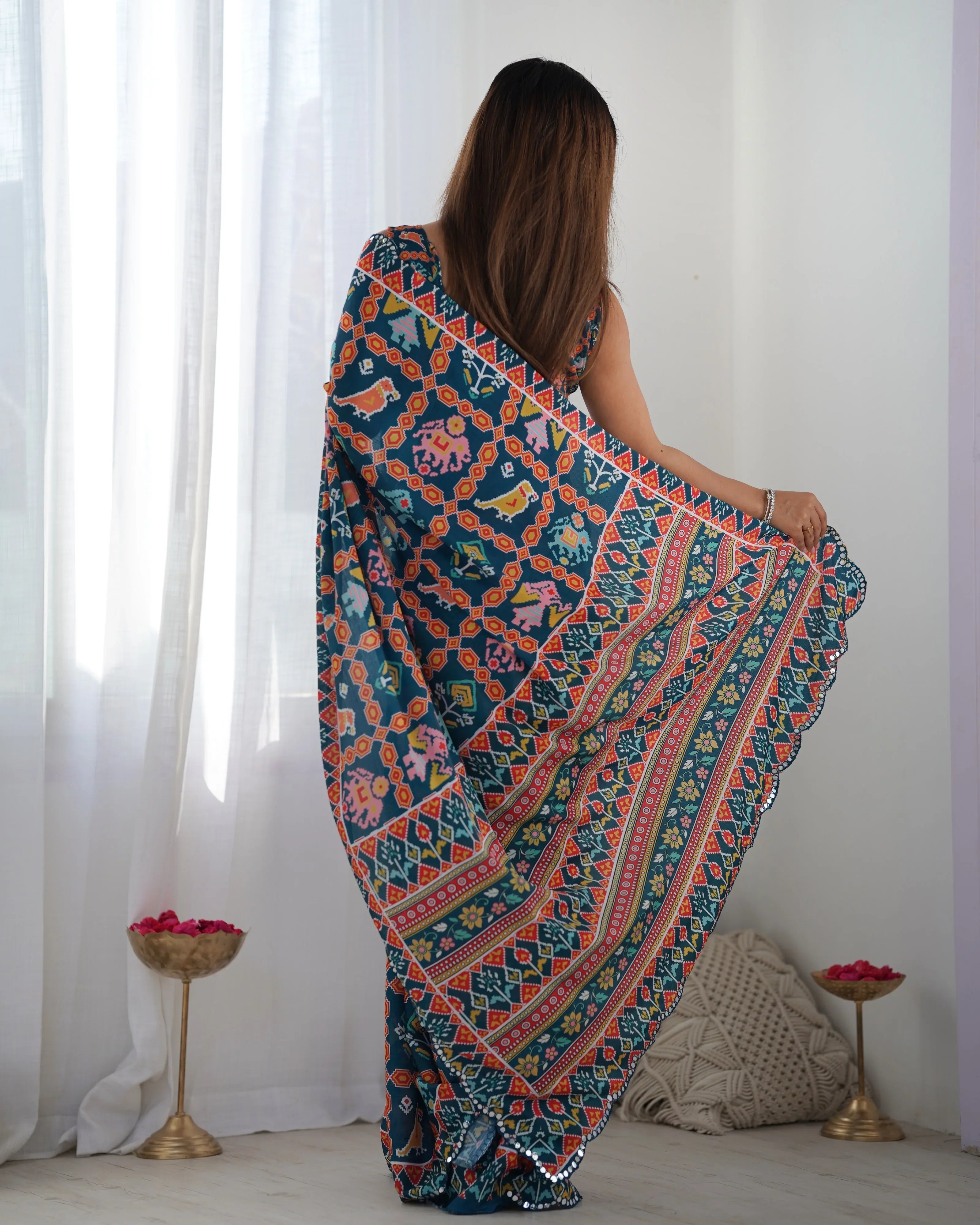 Woman wearing a colorful patterned saree in a minimalistic room Glanzavi