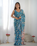 A woman modeling a teal blue and peach printed georgette saree with mirror lace border and a sleeveless blouse Glanzavi
