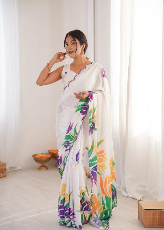 Woman wearing a white saree with colorful floral patterns in a minimal indoor setting Glanzavi.