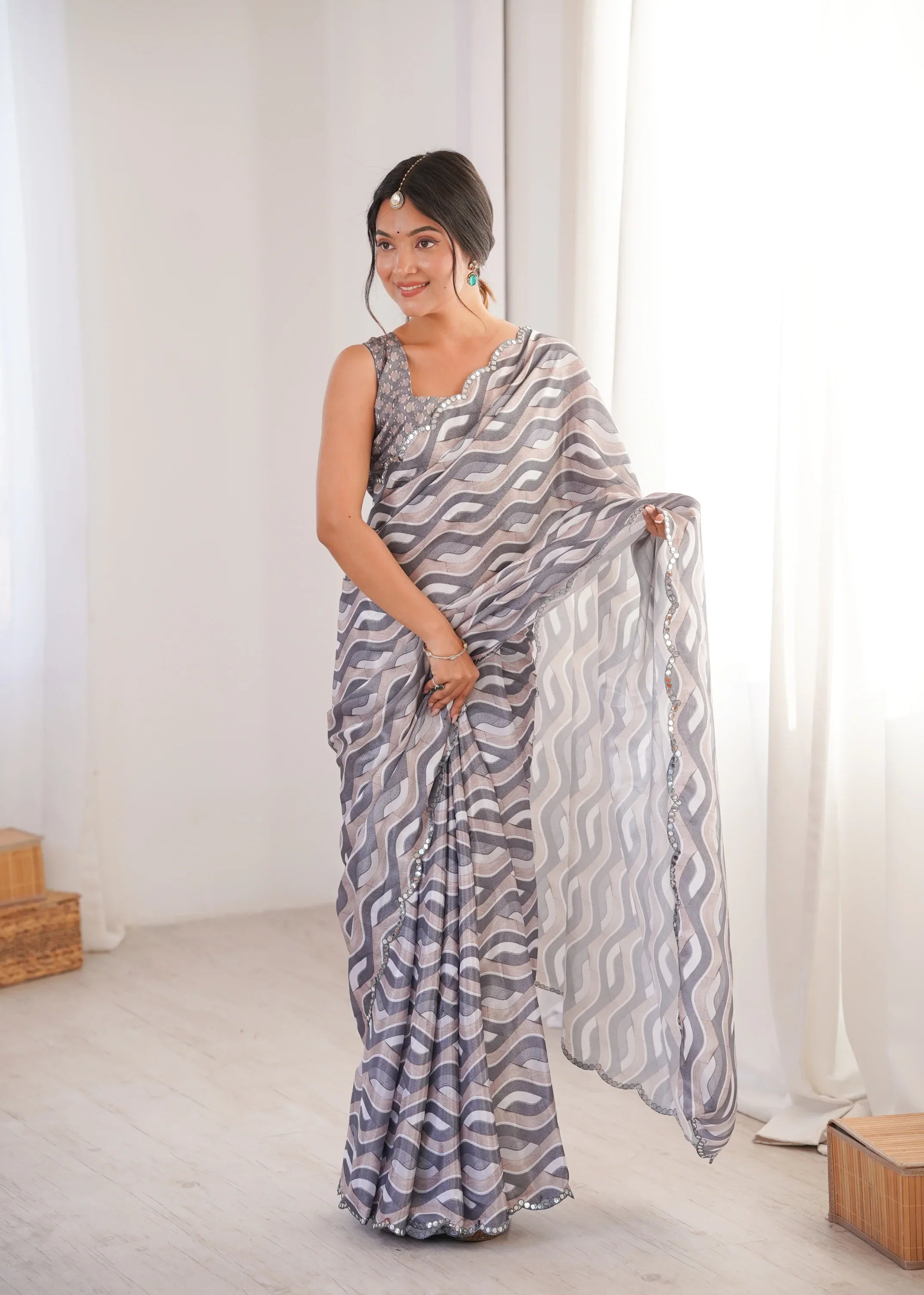 Woman wearing a patterned saree in a bright room with white curtains Glanzavi.