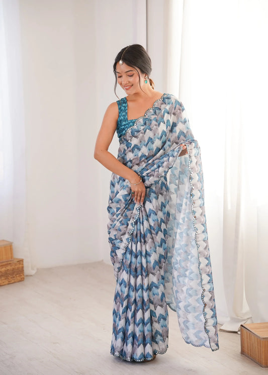 Woman wearing a blue and white patterned saree in a bright room Glanzavi.