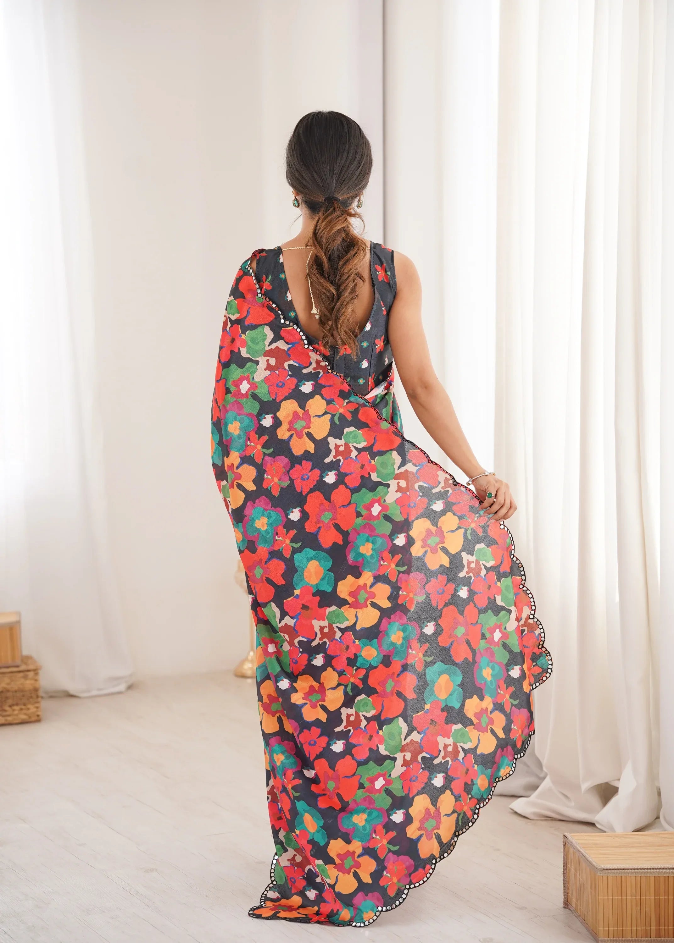 Woman wearing a colorful floral saree in a minimal indoor setting Glanzavi