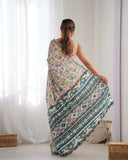 Woman holding a patterned fabric in a room with white curtains and wooden furniture Glanzavi