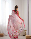 Woman wearing a pink floral saree in a room with white curtains and a light-colored floor Glanzavi