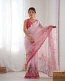Woman wearing a pink saree with floral patterns in a room with white curtains Glanzavi