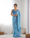 Woman wearing a blue saree with white patterns in a minimalistic room Glanzavi