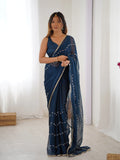 Woman wearing a blue saree with a white background Glanzavi