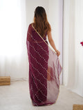 Woman wearing a maroon saree with white patterns in a minimal indoor setting Glanzavi
