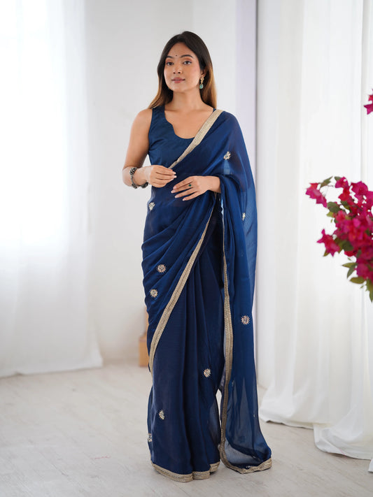 Woman wearing a blue saree with a white background Glanzavi
