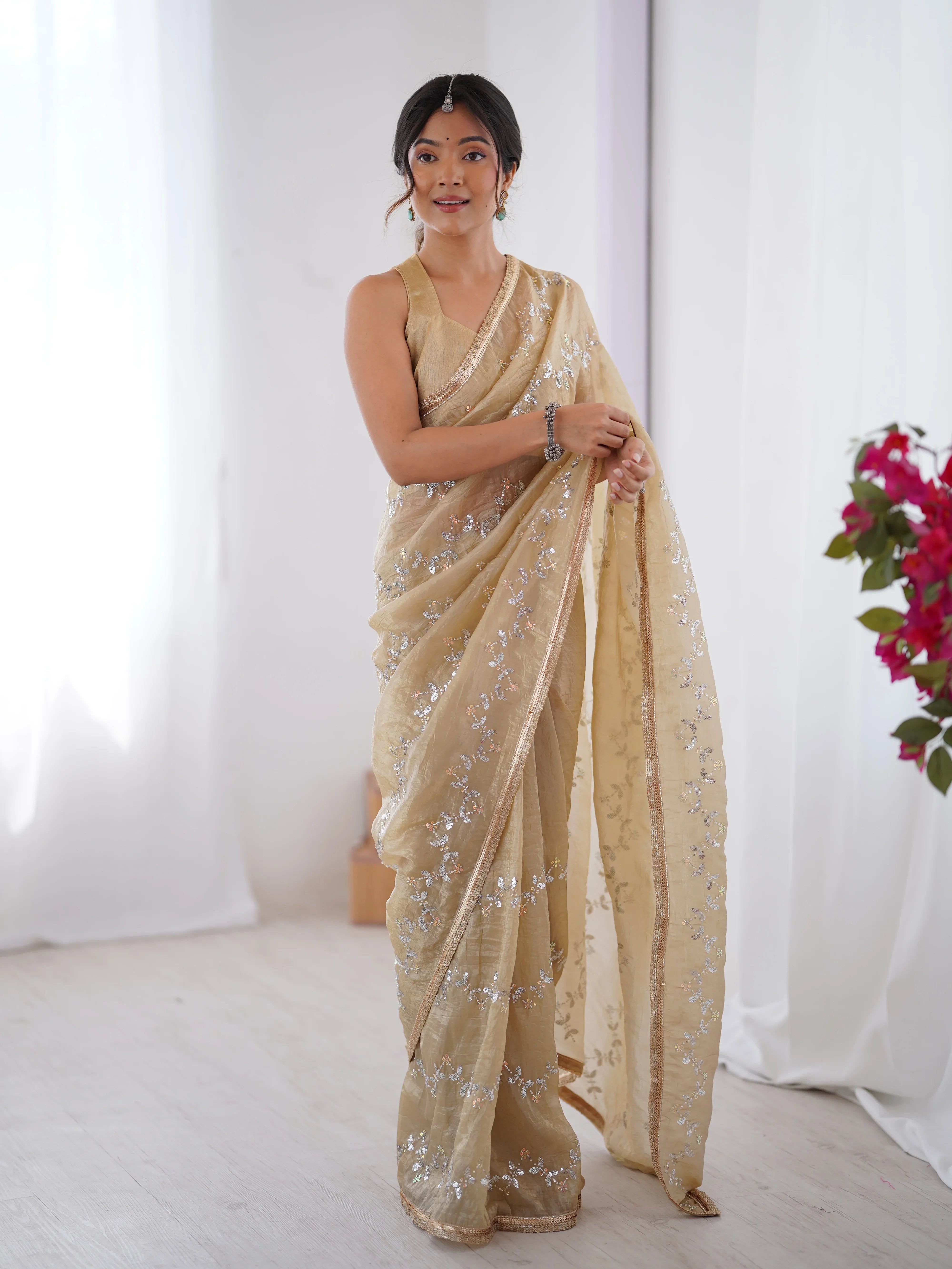Woman wearing a beige saree with silver details against a white background Glanzavi