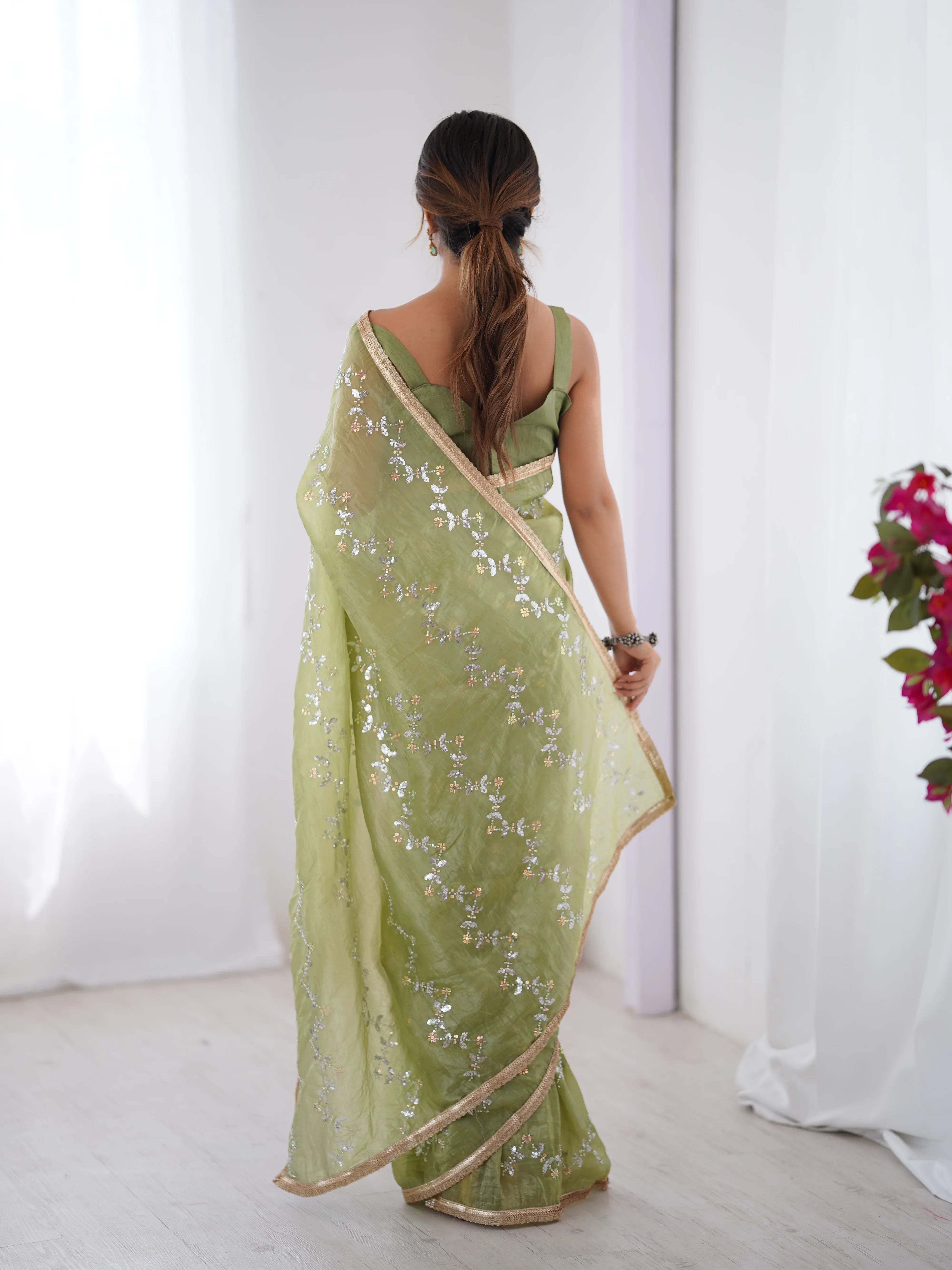 Woman wearing a green saree with a white background Glanzavi