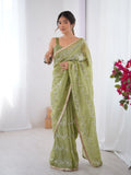 Woman wearing a green saree with a white background Glanzavi