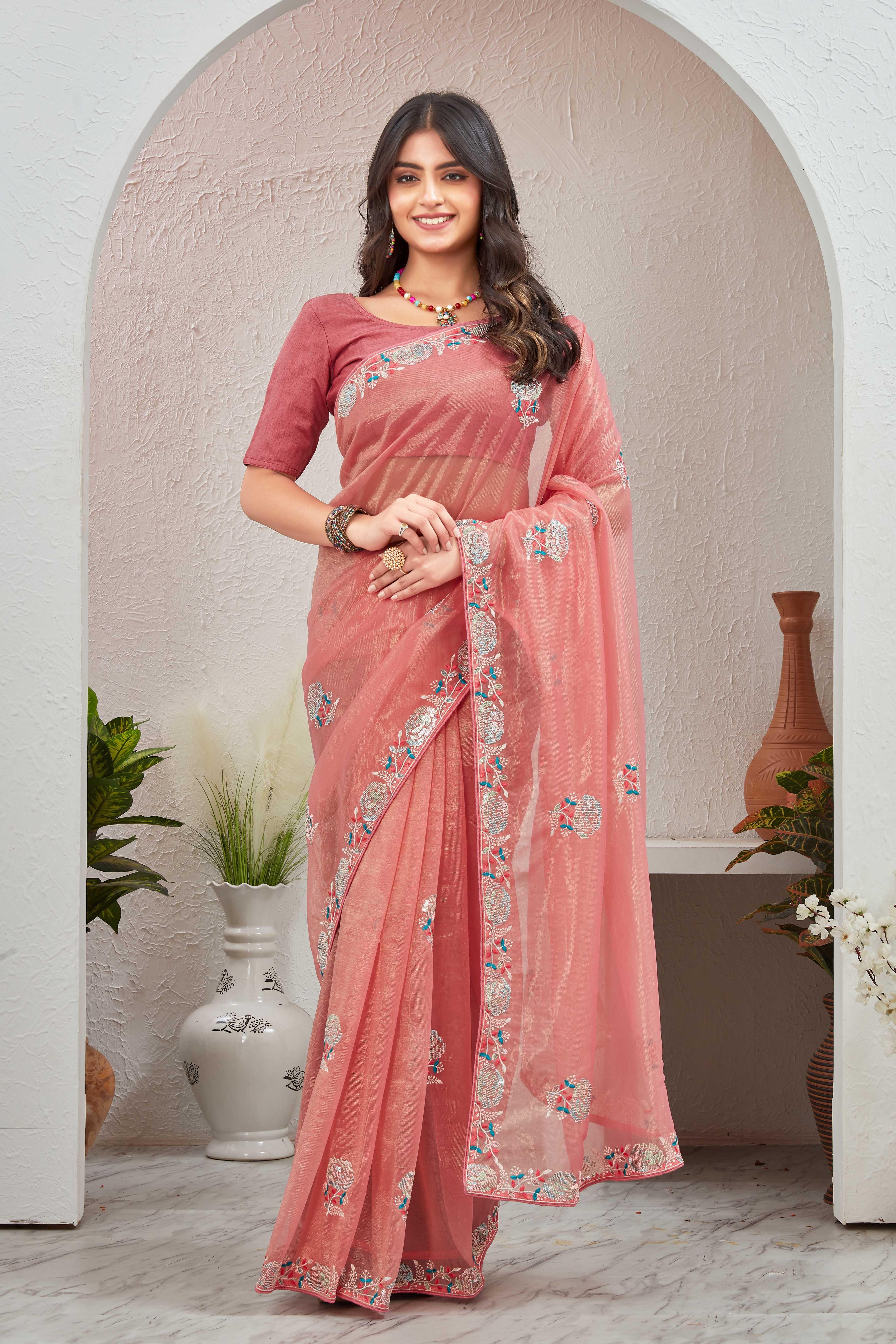 Woman wearing a pink saree with a floral pattern indoors Glanzavi.