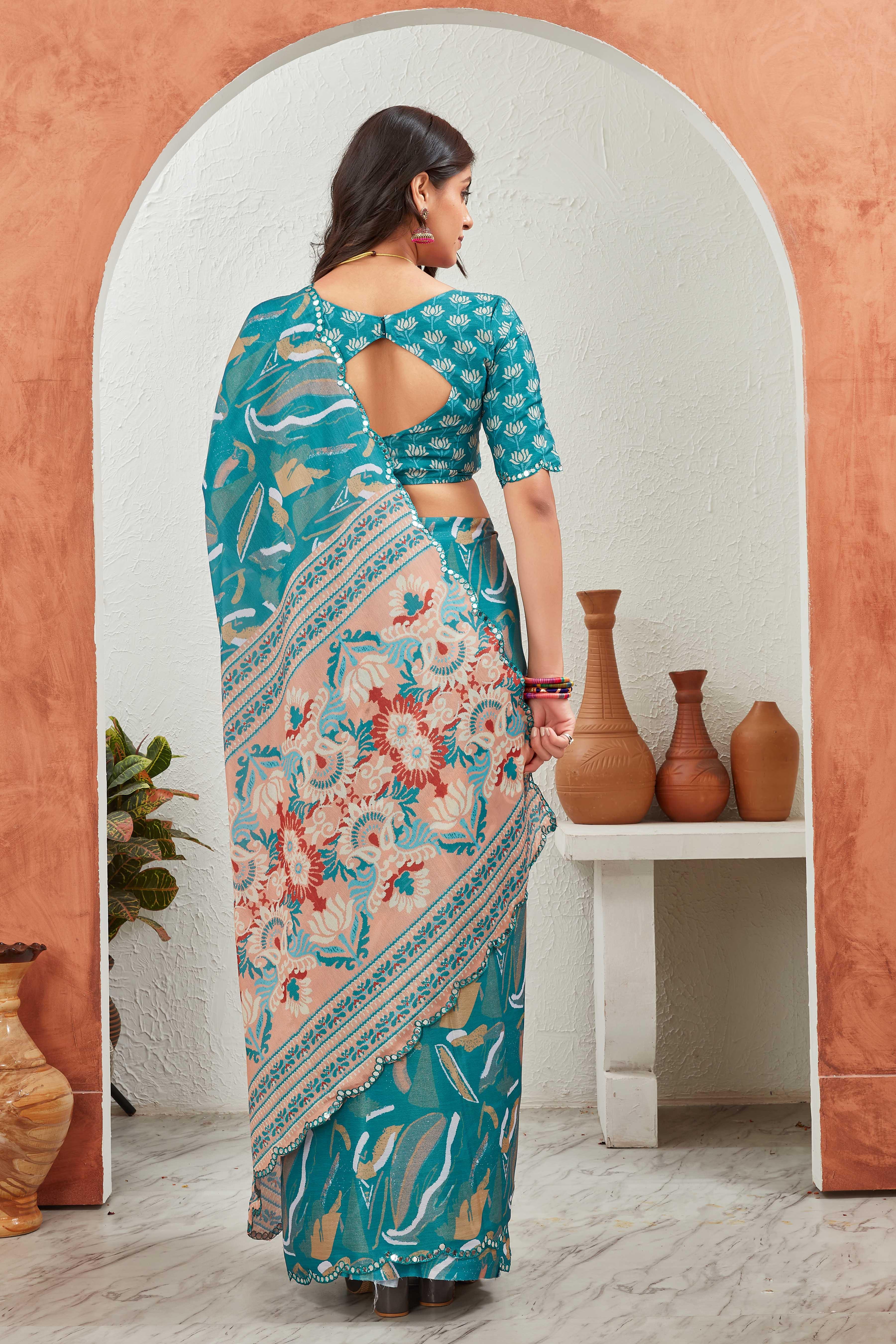 Woman in a floral saree standing in front of an archway with decorative vases Glanzavi