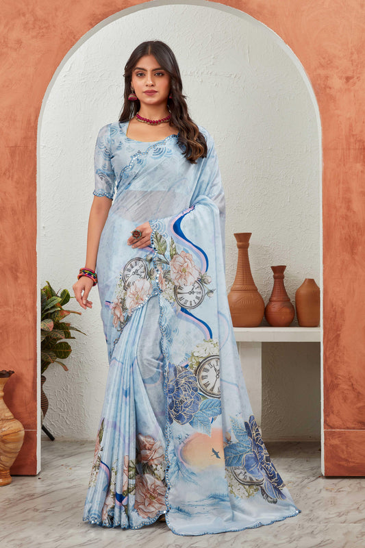 Woman wearing a light blue saree with floral and clock designs in an archway Glanzavi.