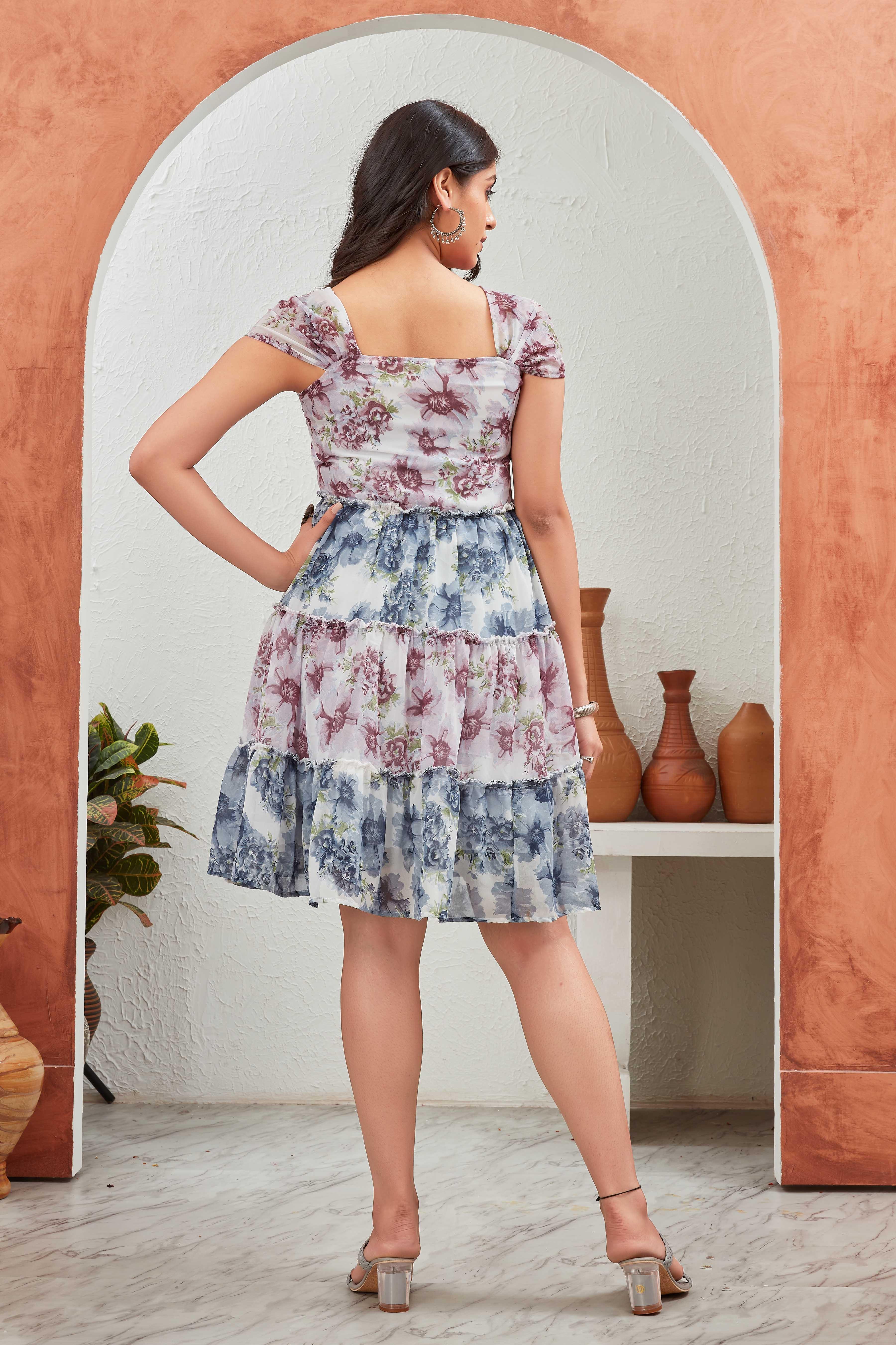 Woman wearing a floral dress standing in front of a mirror Glanzavi