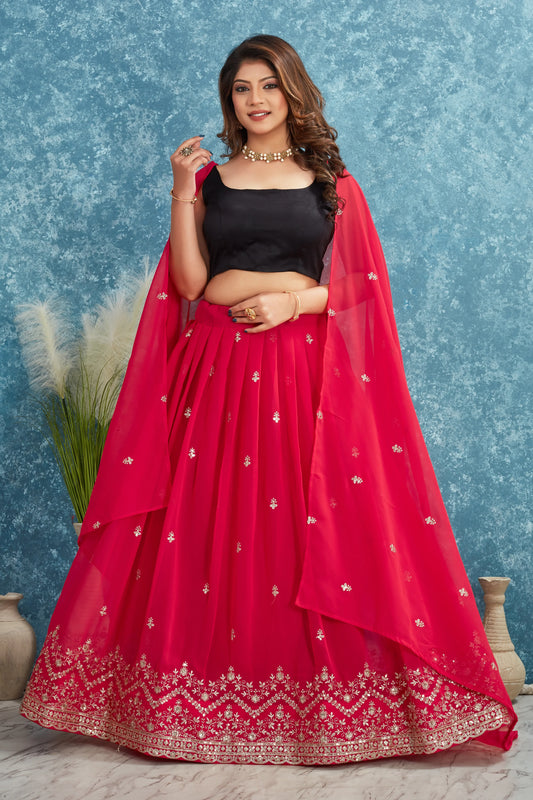 Woman wearing a red embroidered lehenga with a black blouse against a blue textured background Glanzavi