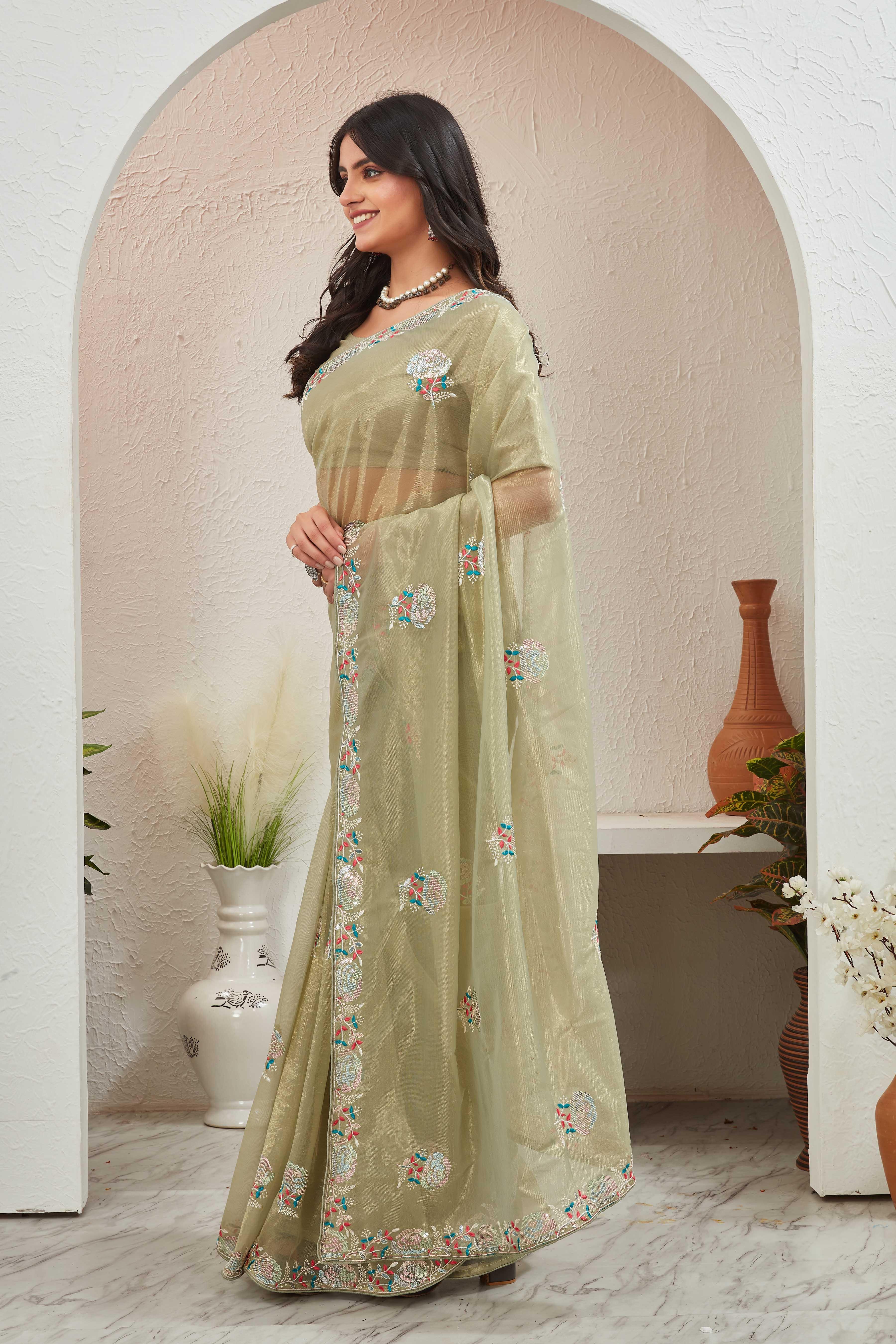 Woman wearing a light green saree with floral patterns in an indoor setting Glanzavi.