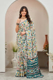 Woman wearing a patterned saree standing in a decorative indoor setting Glanzavi
